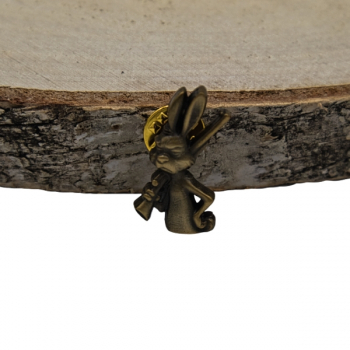 Przypinka myśliwska - zając ze strzelbą na tle kory