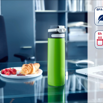 Kubek termiczny Flip 600ml KIWI, widok na szklanym stole